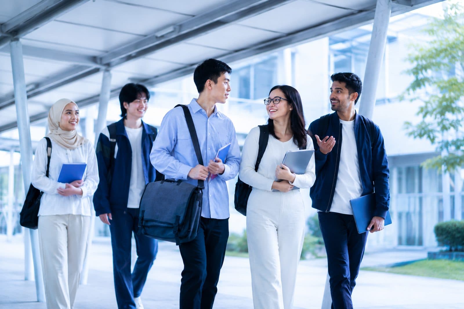 A diverse group of international students chatting as they walk through a modern university campus